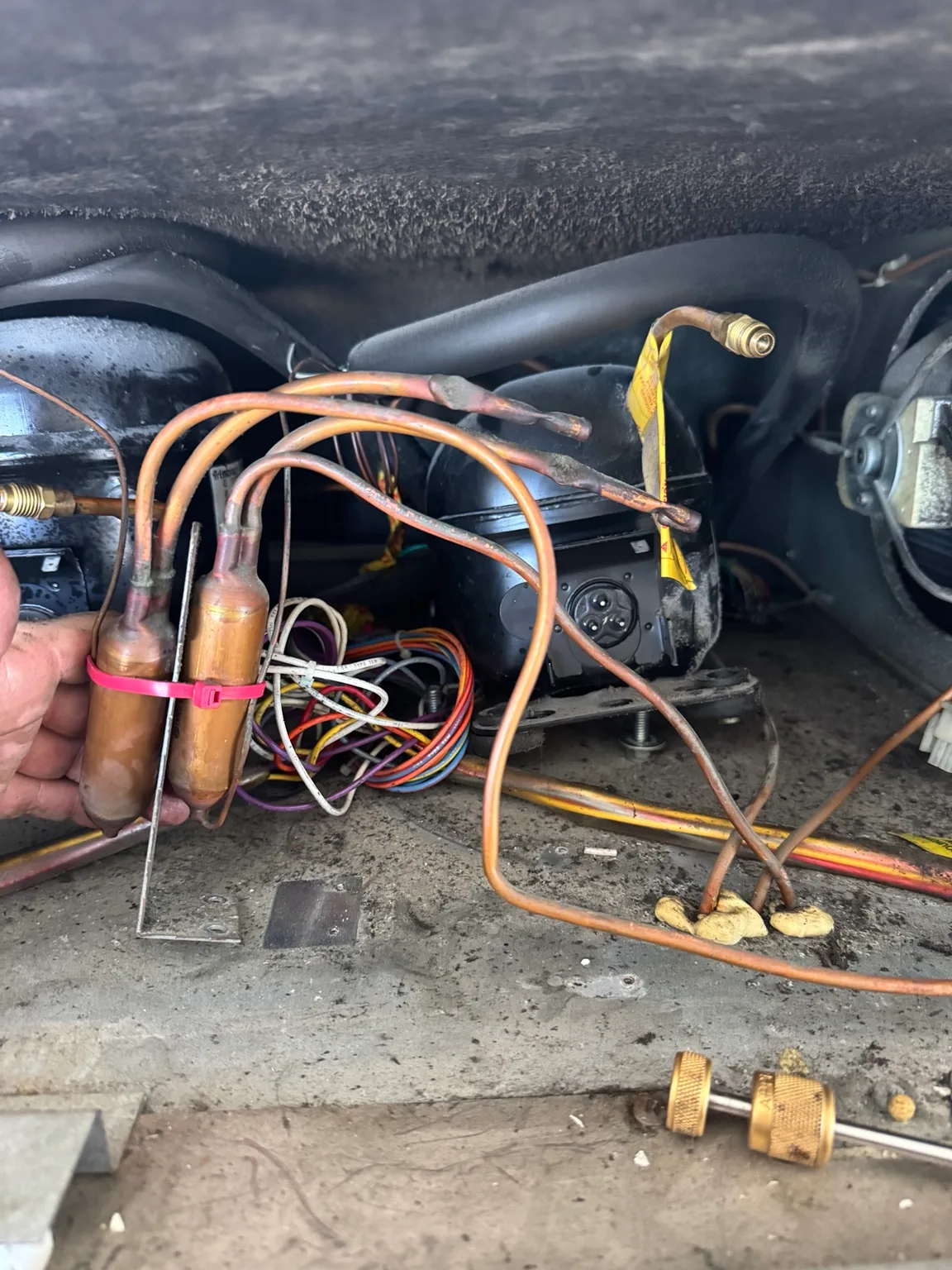 Sub-Zero compressor replacement in progress with refrigeration tubing opened